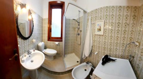 y baño con lavabo, aseo y espejo. en Appartamento Taormina Giardini-Naxos, en Giardini Naxos