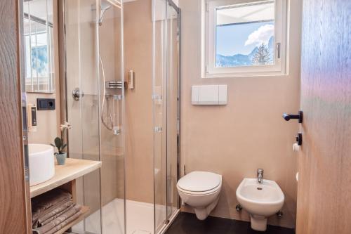 
a bathroom with a toilet, sink, and shower at Turmchalet in Braies
