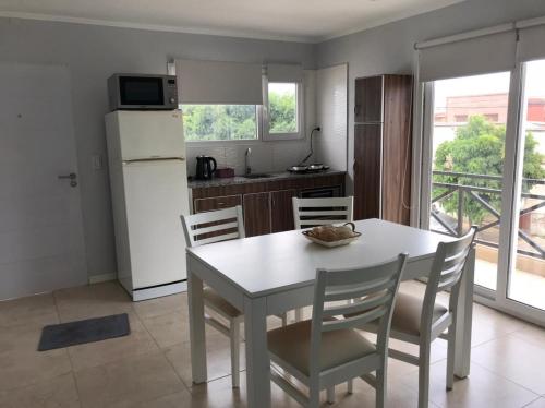 a kitchen with a table and chairs and a refrigerator at Los 7 Deseos in Tandil