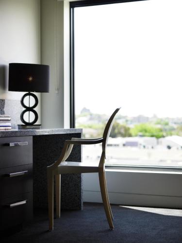 a chair sitting in front of a desk with a window at The Cullen Melbourne - Art Series in Melbourne