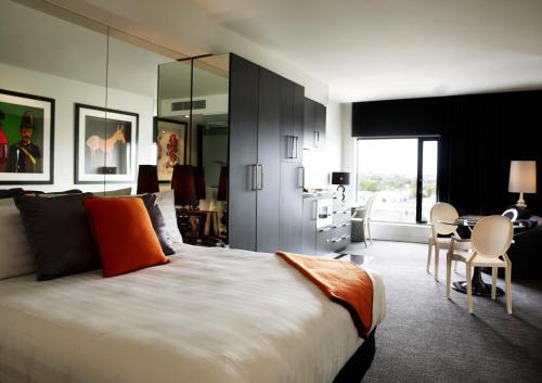 墨爾本的住宿－藝術系列酒店- 卡倫，一间卧室配有一张大床和一张桌子及椅子