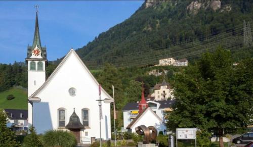 a white church with a steeple in front of a mountain at Studio with wifi at Morschach in Morschach