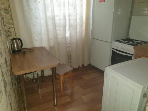 uma pequena cozinha com uma mesa e um frigorífico em Квартира проспект Кирова (Александра Поля).Юность em Dnipro