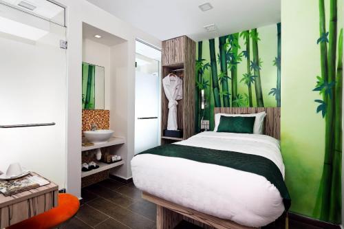 a bedroom with a bed and a green wall at Hotel Clover The Arts in Singapore