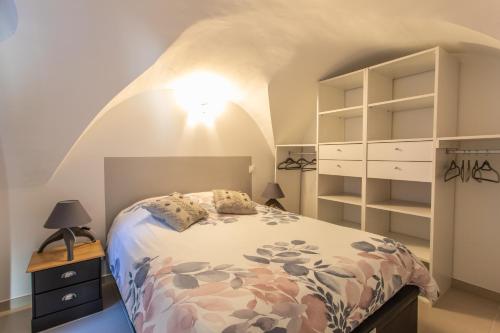 a bedroom with a bed and a dresser and shelves at Rez-de-chaussée centre ville d'Embrun 3 étoiles in Embrun