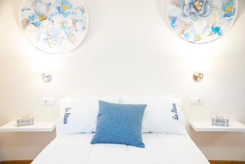 1 dormitorio con cama blanca y almohada azul en CASA LAS PALMERAS, en Cambados