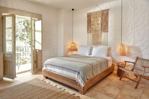a bedroom with a bed and a chair and a window at Morro Alacati in Alacati