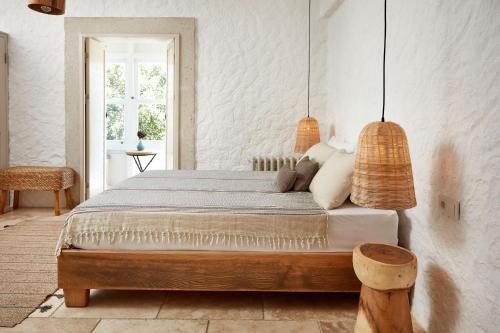 a bedroom with a bed and two pendant lights at Morro Alacati in Alacati