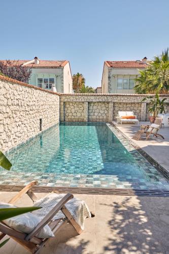 a swimming pool next to a stone wall at Morro Alacati in Alacati