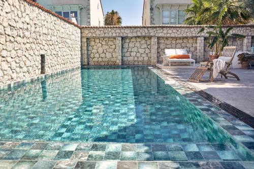 a swimming pool next to a stone wall with at Morro Alacati in Alacati