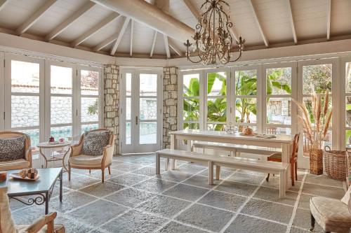 a living room with a table and chairs and windows at Morro Alacati in Alacati