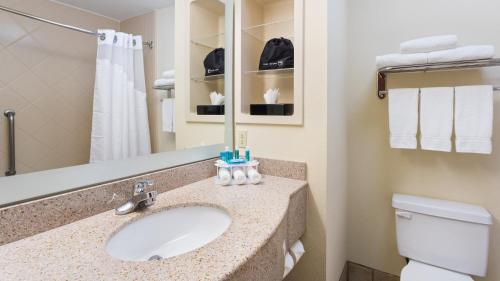 a bathroom with a sink, mirror, and toilet at Holiday Inn Express Hotel & Suites Twentynine Palms, an IHG Hotel in Twentynine Palms