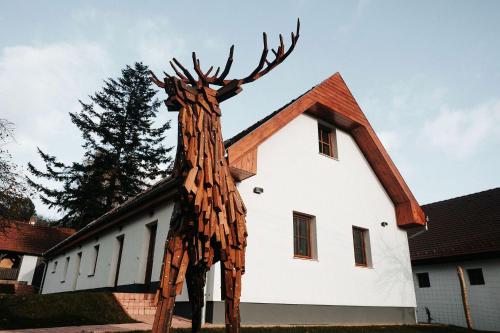 a wooden giraffe statue in front of a building at GLASHÜTTE Kisújbánya Vadászház in Hosszúhétény