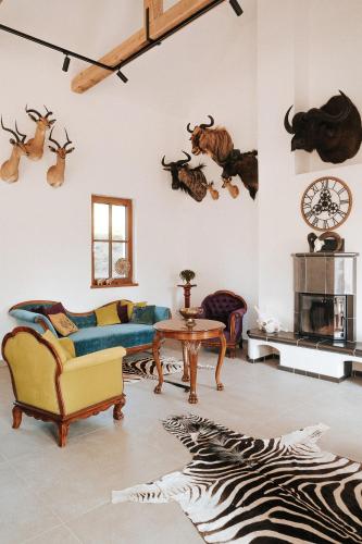 a living room with a couch and antlers on the wall at GLASHÜTTE Kisújbánya Vadászház in Hosszúhétény