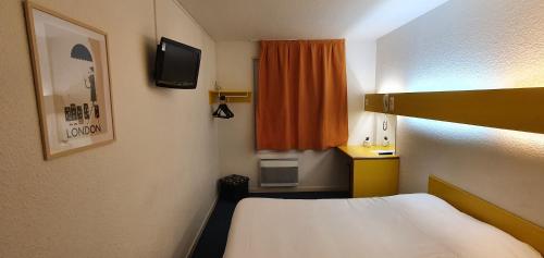 a small room with a bed and a television at Quick Palace Anglet in Anglet