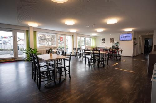 uma sala de jantar com mesas e cadeiras num restaurante em Nyon Hostel em Nyon