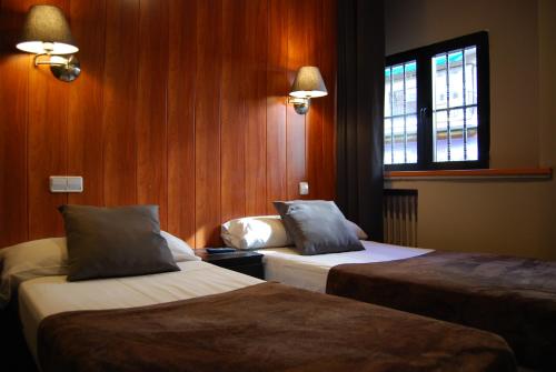 a hotel room with two beds and a window at Hostal Don Pedro in Madrid