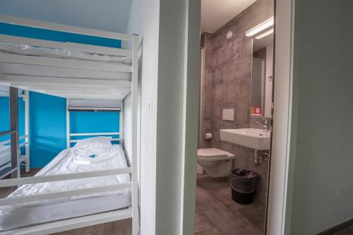 a small bedroom with a bunk bed and a bathroom at Nyon Hostel in Nyon