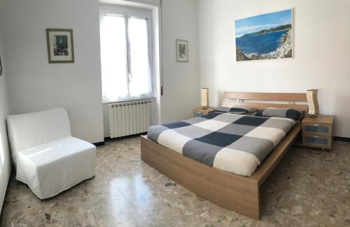 - une chambre avec un grand lit et une chaise dans l'établissement HOST IN LEVANTO - Scirocco con biciclette, à Levanto