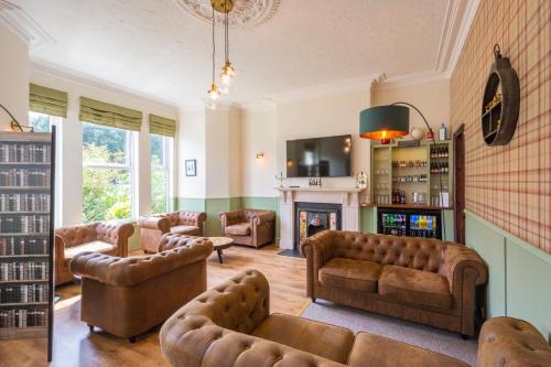 a living room with leather furniture and a fireplace at HK Rooms - Self Catering Rooms in Lowestoft