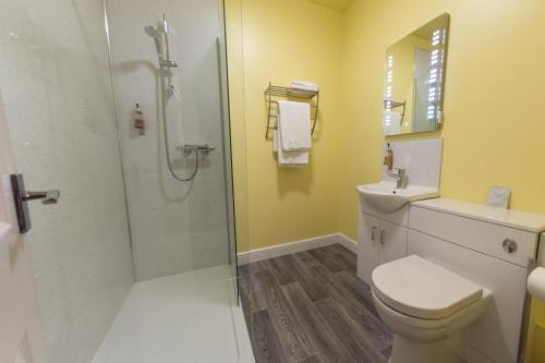 a bathroom with a shower and a toilet and a sink at HK Rooms - Self Catering Rooms in Lowestoft