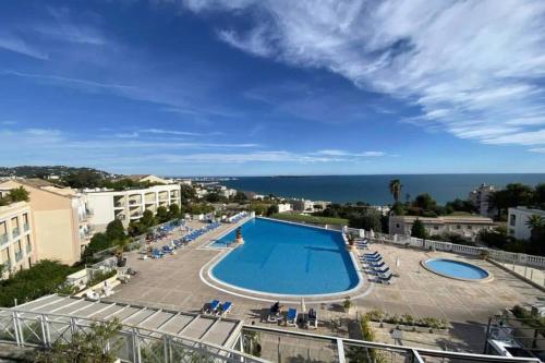 - une vue sur la piscine avec des chaises et l'océan dans l'établissement C021 Lumineux appartement avec Terrasse et Piscine, à Cannes