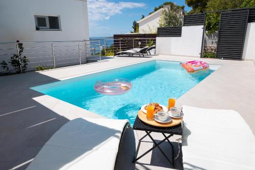 a small swimming pool with a table in a backyard at Entire private top floor with own pool and entrance in Primošten