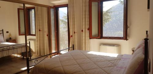 a bedroom with a bed in a room with windows at villa del maestro in Lenola