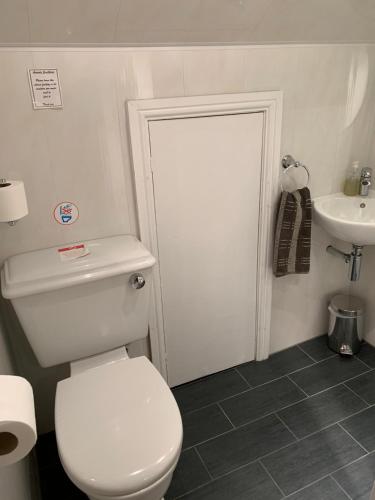 a bathroom with a white toilet and a sink at Armada Guesthouse in Redcar
