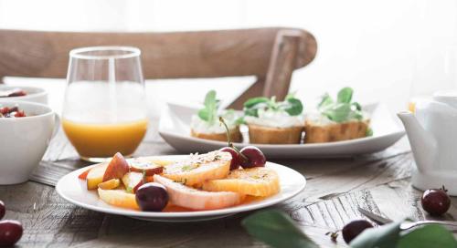 a table with two plates of food and a glass of orange juice at Hotell Nivå in Boden
