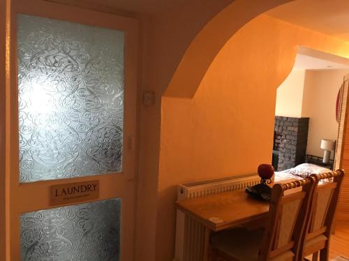 a dining room with a table and a door to a room at Ground Floor - view of Lighthouse, Garden and Parking in Swansea