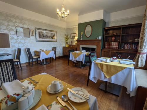 ein Esszimmer mit 2 Tischen und einem Kamin in der Unterkunft Shibden Hall View in Halifax