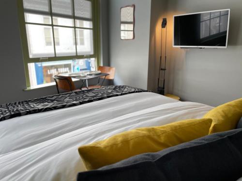 a bedroom with a bed with a tv on the wall at Daen’s Greenhouse in Utrecht