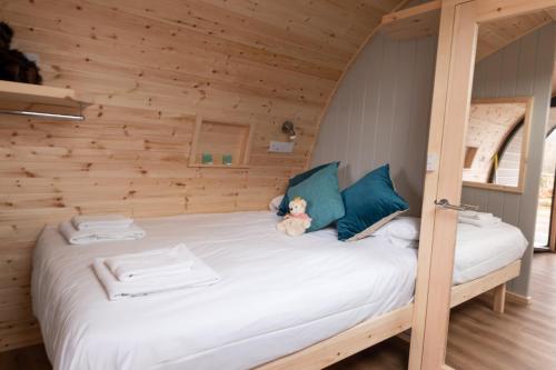 a bed in a wooden room with a teddy bear sitting on it at Callander Hostel in Callander