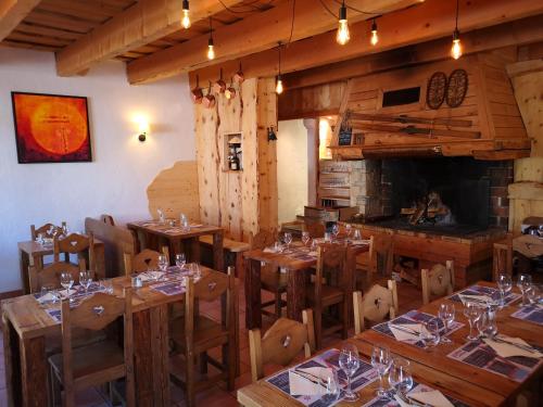 un restaurante con mesas y sillas de madera y chimenea en Auberge des deux Moucherolles en Corrençon-en-Vercors