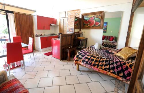 a bedroom with a bed and a kitchen with red cabinets at Majikal B&B - Jacaranda in Cholula
