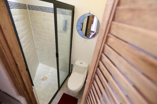 a small bathroom with a toilet and a mirror at Majikal B&B - Jacaranda in Cholula