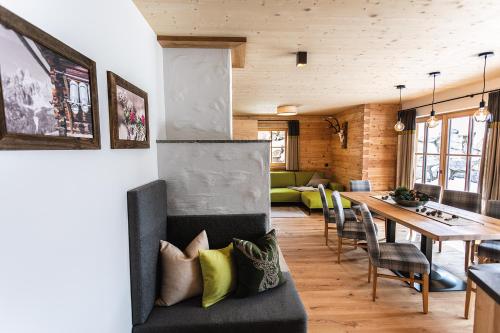 Bergseegut Chalet und Apartment في واغراين: غرفة معيشة مع طاولة وغرفة طعام