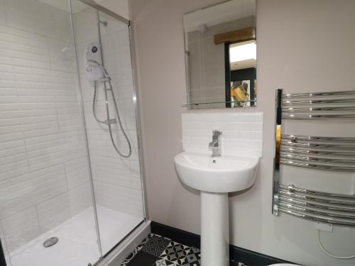 a white bathroom with a sink and a shower at The Forge in Lincoln