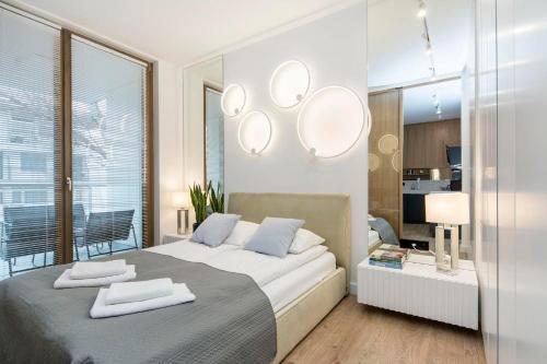 a bedroom with a large bed with mirrors on the wall at Margo Rentyear Apartments in Gdańsk