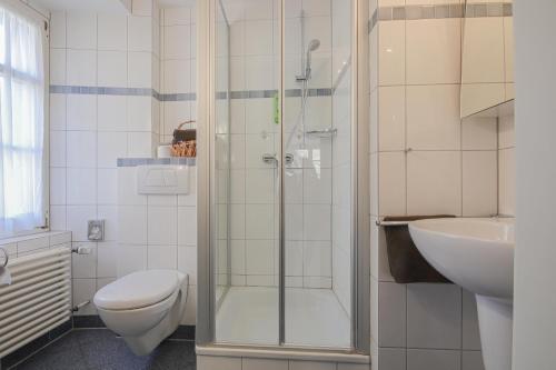 a bathroom with a shower and a toilet and a sink at Landgasthof Hotel Rebstock in Stühlingen