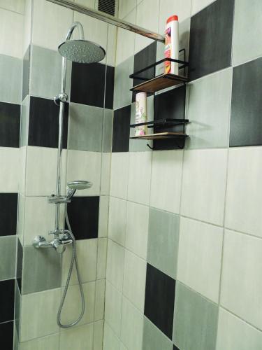 La salle de bains est pourvue d'une douche avec du carrelage noir et blanc. dans l'établissement Appart'AZUR Haguenau - Hyper centre Mairie - Parking facile - Wifi - Lit confort Kingsize, à Haguenau