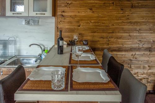 a dining room table with a bottle of wine and glasses at Guest house Viki in Veliko Tŭrnovo