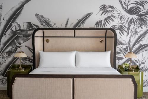 a bedroom with a large bed and palm trees mural at PGA National Resort in Palm Beach Gardens