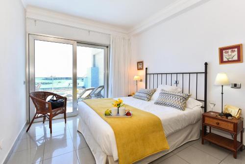 a bedroom with a large bed and a large window at Luxury BeachFront Mogan in Puerto de Mogán