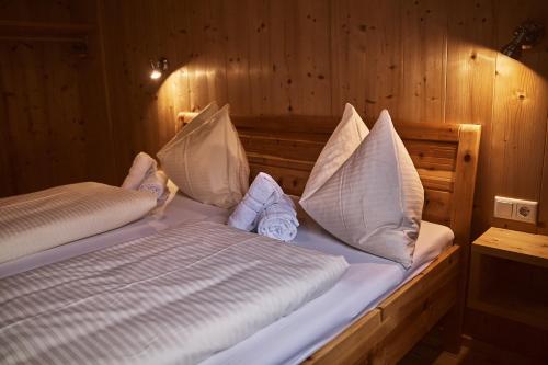 a bed in a wooden room with pillows on it at Chalet Ablon in Saalbach Hinterglemm