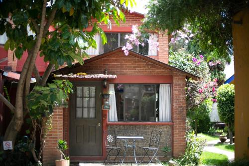 a small brick house with a table and a door at Majikal B&B - Cabañita in Cholula