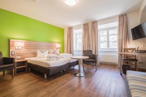 a hotel room with a bed and a table at Landgasthof Hotel Rebstock in Stühlingen