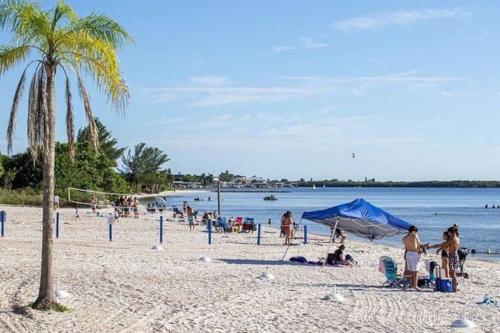 a group of people on a beach with a palm tree at Little Harbor Resort #114 Tampa Bay FL Beach, Bayside & 2 Pools in Ruskin