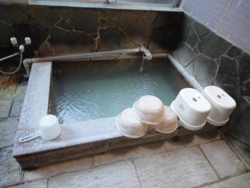 a bath tub filled with water in a bathroom at Kinreisou in Hakone